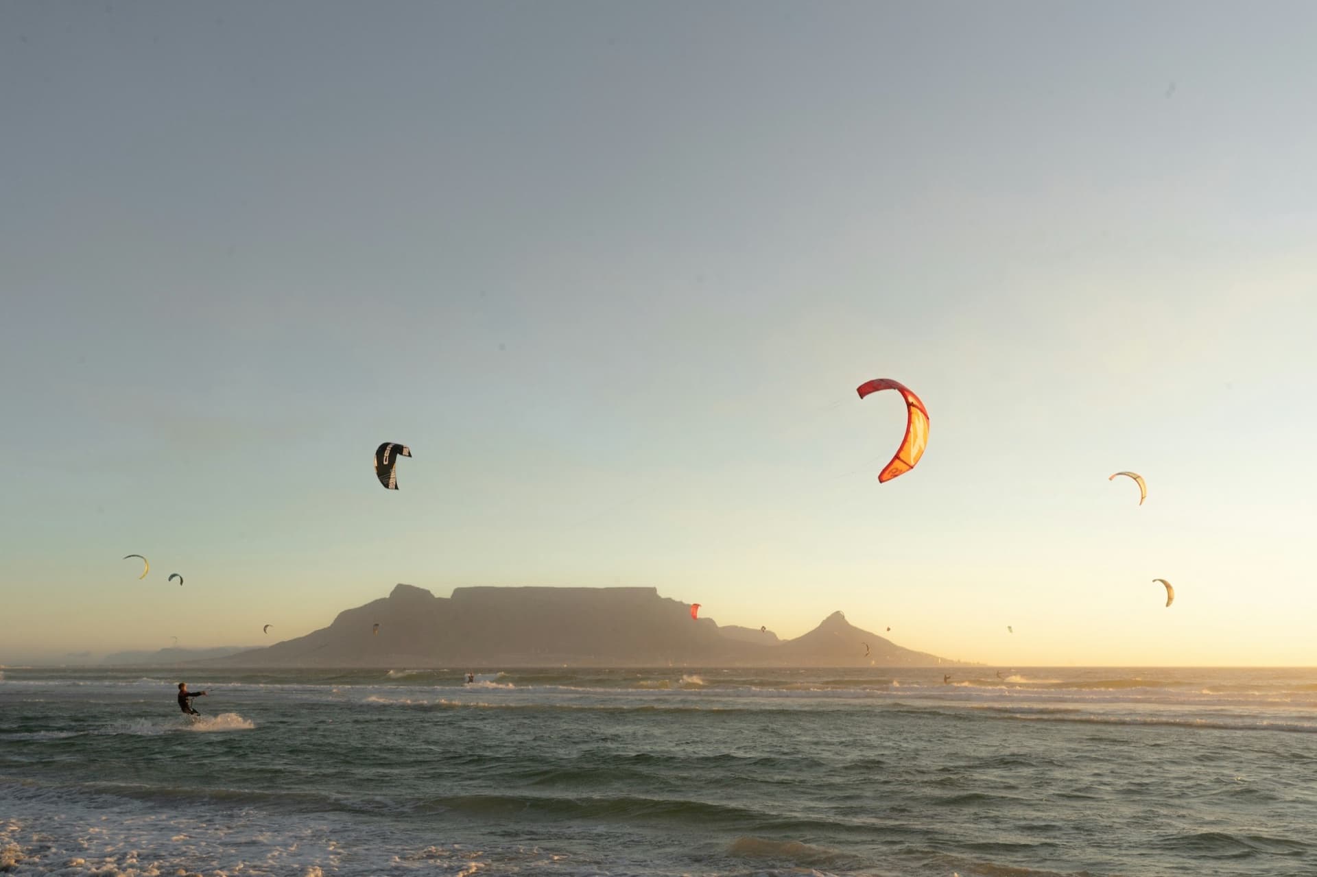 Kitesurfers on the Atlantic seaboard at Bloubergstrand with Table Mountain across the bay