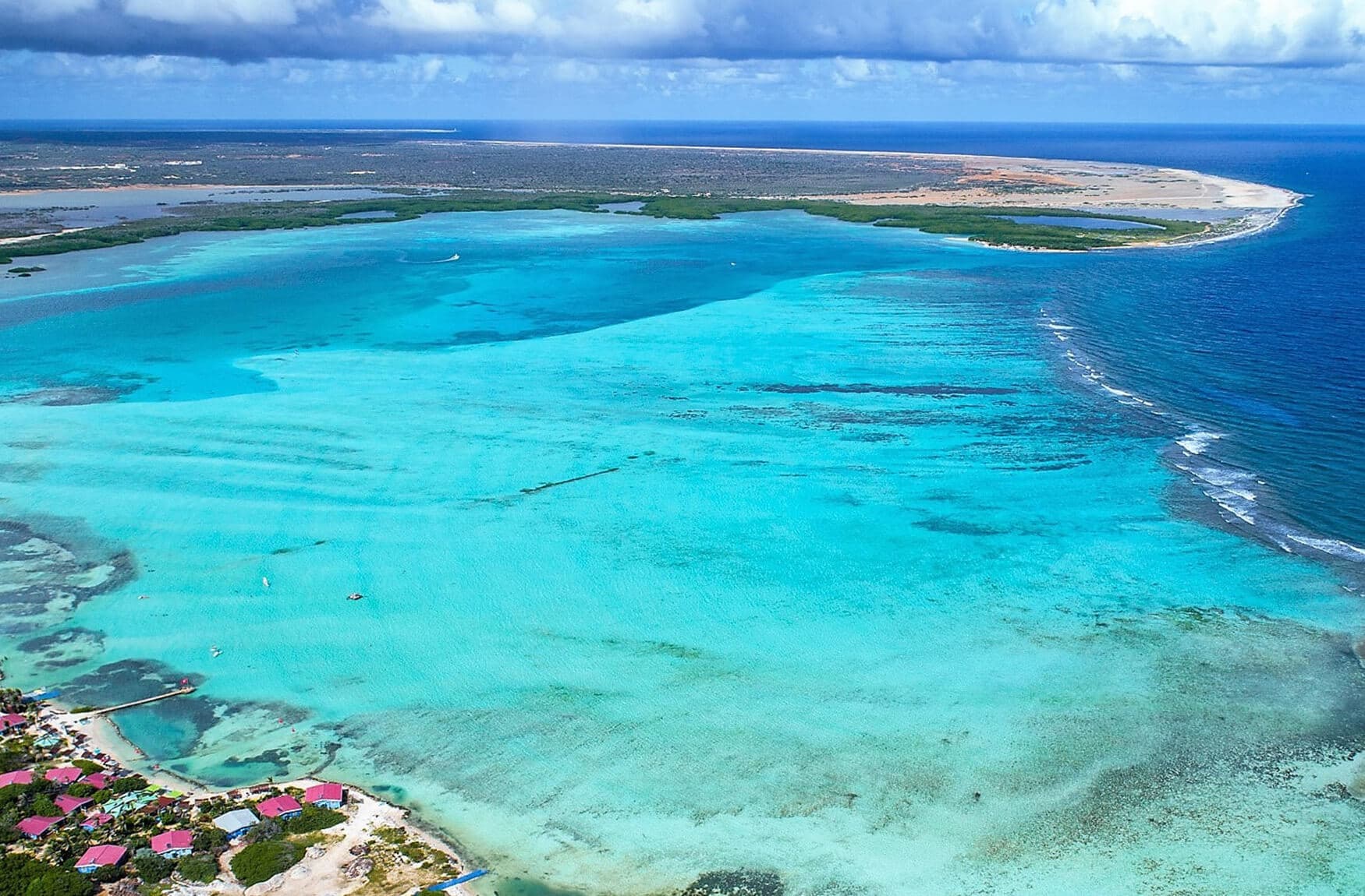 Beginner windsurfers on the shallow flat turquoise lagoon at Lac Bay, Bonaire