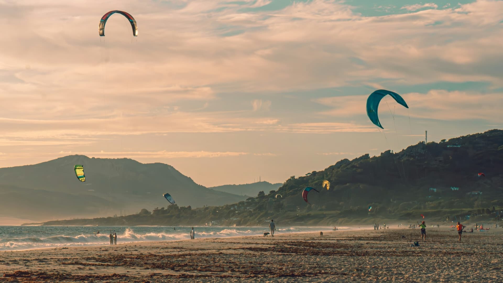 Kitesurfers and kites at golden hour over the long beach at Tarifa, Spain