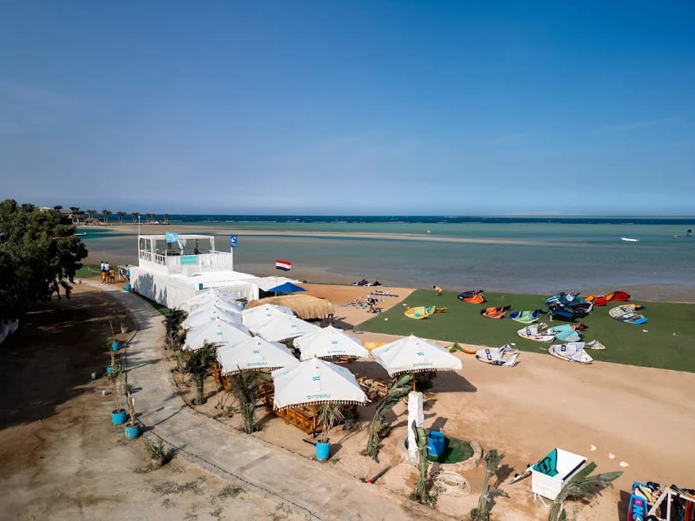 An aerial view of a kite centre at El Gouna with gear laid out on the lawn and the shallow lagoon behind