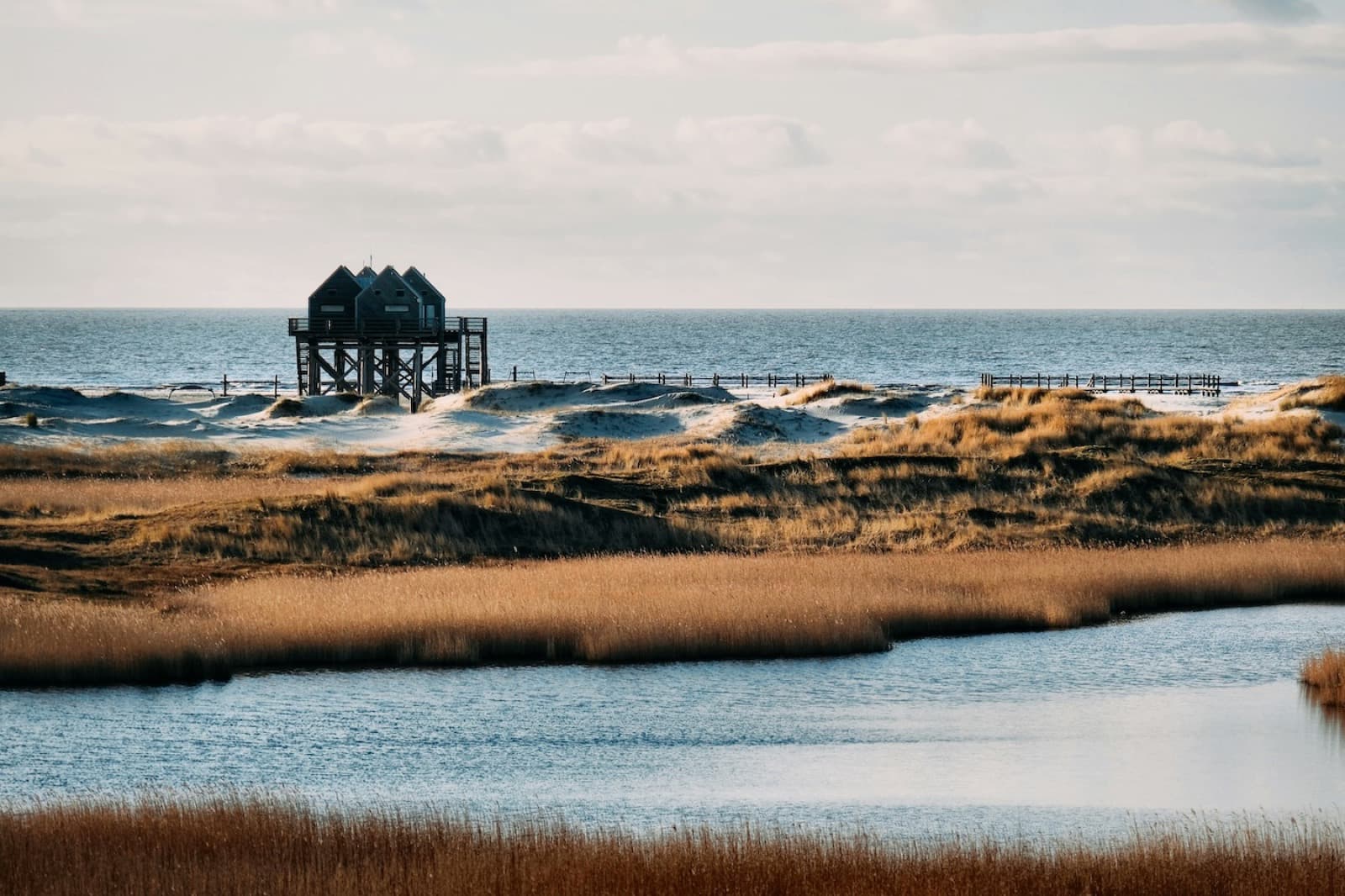 Kitesurfers spread across the vast sandy tidal flats at St. Peter-Ording on the German North Sea coast