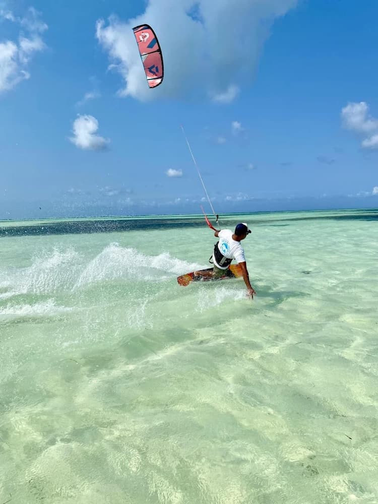 A kitesurfer crossing the shallow flat lagoon at Paje at low tide under a clear sky